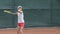 Young ambitious healthy lifestyle, serious determined tennis player child girl hitting racket on ball at professional
