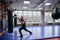 Young ambitious sportsman practising boxing at gym with modern interior