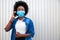 Young american african woman, dressed casual, wearing disposable medical protective mask