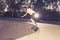 Young American man practicing radical skate board having fun enjoying tricks jumps and stunts in concrete half pipe skating track