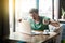 Young angry businessman in green t-shirt sitting with aggressive face and boxing fists and try to punching his laptop