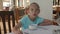 Young angry girl sitting at table in cafe during breakfast