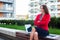 Young angry professional business woman sitting outdoor with arm