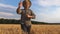 Young annoyed agronomist running to camera through the wheat field and trying to catch somebody. Angry farmer jogging