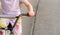 Young anonymous unrecognizable school age child riding an old used second hand bike, holding hands on handlebars closeup, detail,