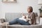 Young Arab Housewife Relaxing At Home With Smartphone And Coffee