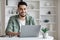 Young arab male writer working on laptop computer at home office