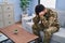 Young arab man army soldier stressed sitting on sofa with hands on head at home