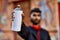 Young arab man relaxed holding graffiti spray at street