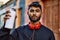 Young arab man relaxed holding graffiti spray at street