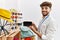 Young arab man shopkeeper holding sunglasses working at clothing store