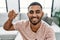 Young arab man smiling confident holding key of new house at home