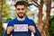 Young arab man smiling confident holding respect banner at park