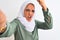 Young Arab woman wearing hijab taking selfie photo over isolated background annoyed and frustrated shouting with anger, crazy and