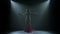 Young Arabian belly dancer in exotic dance holding a golden cane on his head. Shot in a dark studio with smoke and neon