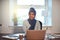 Young Arabic female entrepreneur smiling while working from home