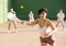 Young Argentinian woman playing pelota at open-air fronton in summer