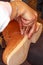 young artisan woman works on the top of a wooden and leather clog.