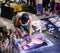 A young artist paints a picture of multicolored spray paint at night in front of everybody. A young  guy in a respirator.