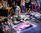 A young artist paints a picture of multicolored spray paint at night in front of everybody. A young  guy in a respirator.