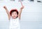 Young Asia boy in gray T shirt wearing a orange safety helmet and holding triangular reduction scales and raise hand up in the gar