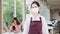 Young Asia female restaurant staff wearing protective face mask holding alcohol and wet wipe before welcome customer with customer