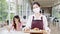 Young Asia female restaurant staff wearing protective face mask holding food tray to serving meal to customer with customer in