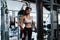Young Asia lady exercise doing exercise-machine Cable Crossover fat burning workout in fitness class. Athlete with six pack,