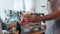 Young Asia male barista serving take away hot coffee paper cup to consumer standing behind bar counter at cafe restaurant. Owner