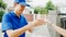 Young Asia postal delivery courier man in blue shirt handling food boxes for sending to customer at house and Asian female receive