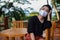 Young Asia woman sitting on the chair wood and put on a face mask to protect from airborne respiratory diseases as the flu dust