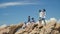 Young asian adult men standing on top of rocks by the sea