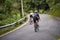 young asian adults riding bike on rural road