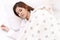 Young asian attractive woman sleeping in soft white pillow and bed on top view with white shirt pajamas and stars blanket.