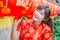 Young asian beautiful girl in chinese traditional red dress smile stand near china lamp, in the Chinese New Year. Festivities.