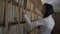 Young asian biologist student in white shirt taking old book from a bookshelf