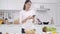 Young Asian blogger woman using smartphone photo post in social media in the kitchen, female making salad at home.