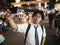 Young Asian business man taking a picture or selfie in the street at night. Social and internet of thing concept