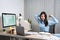 Young Asian Business woman sitting on the chair stretching herself and exercise for relaxation while working hard at office