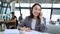 Young Asian business woman wearing suit talking on phone working in office.