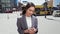 Young Asian business woman wearing suit using smartphone standing in big city.
