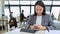 Young Asian business woman wearing suit working in office using cell phone.