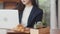 Young Asian business women working on laptop at coffee shop. Asian happy girl barista waiter wear gray apon serve hot cup of