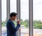 Young Asian businessman drinks coffee in the office window in a comfortable