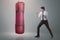 Young asian businessman punching boxing bag