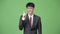 Young Asian businessman smiling pointing finger up