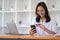 Young Asian businesswoman enjoy shopping online using credit card at a coffee shop.