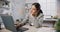 Young Asian businesswoman sit on desk with laptop overworked tired burnout syndrome at office. Exhausted lady with sleeply eye at