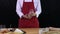 Young Asian Chef in red apron pick up mixing milk glass to check