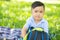 Young asian child smiling and opening backpack in the lawn, asia kid cute expression fun and happy open school bag